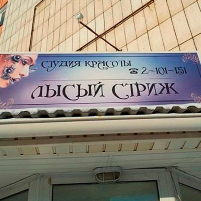 Вывеска студии красоты ЛЫСЫЙ СТРИЖ на входе в здание